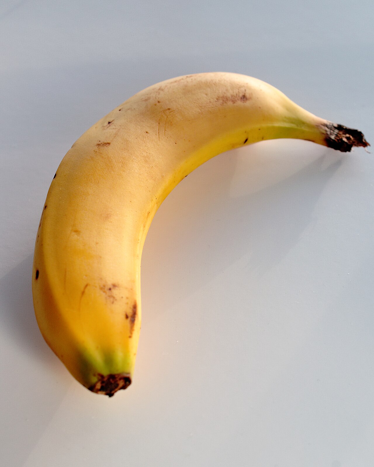 A single yellow banana on a white background