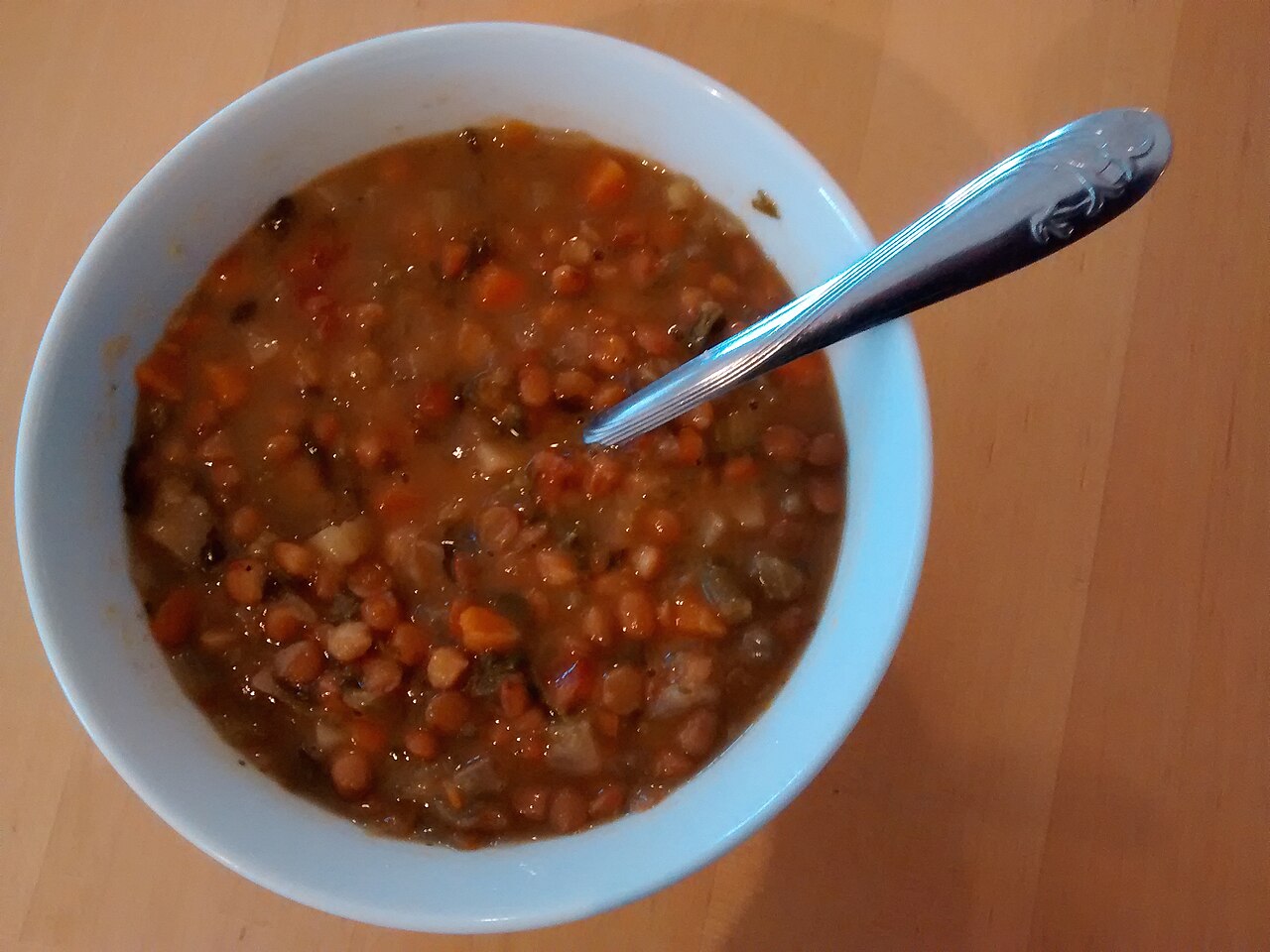 A bowl of thick soup with a spoon