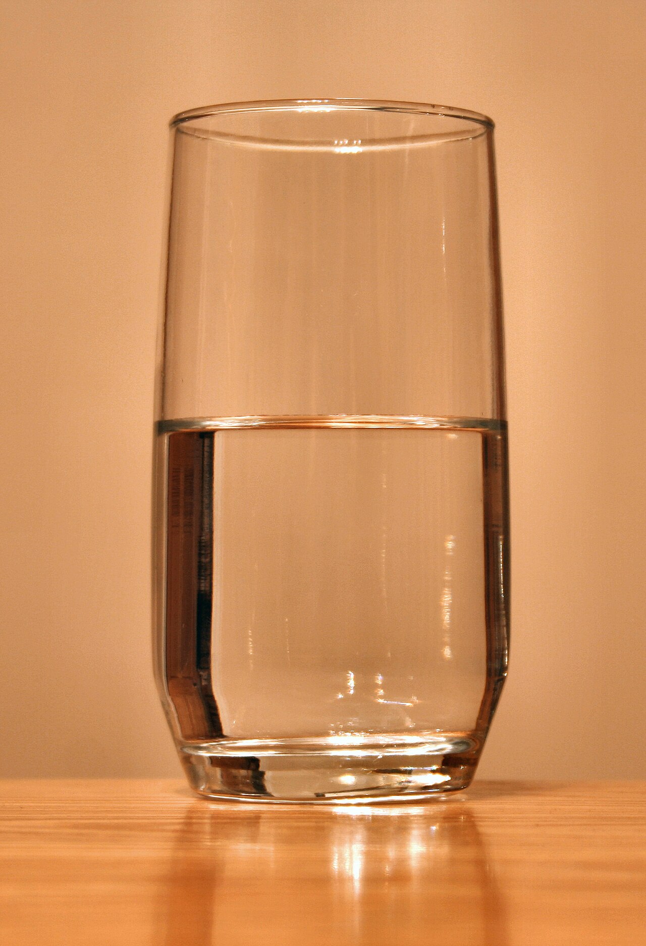 A clear glass of water on a wooden table